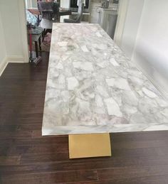 a white marble table with gold legs in a kitchen