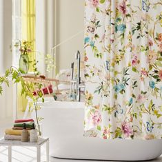 a white sink sitting next to a bath tub in a bathroom under a shower curtain