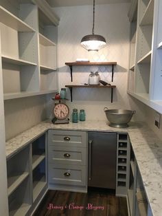 a kitchen with open shelving and wooden flooring next to a counter top oven