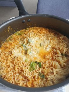 a pot filled with noodles and broccoli on top of a stove burner