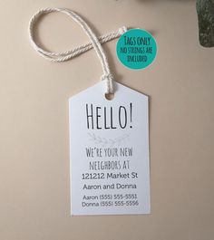 a white tag with the words hello on it hanging from a string next to a potted plant