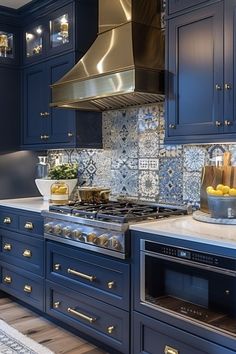 a kitchen with blue cabinets and stainless steel stove top oven, range hood, and counter tops