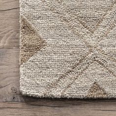 a beige and brown rug on top of a wooden floor