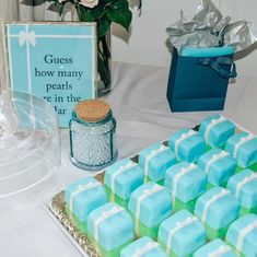 blue and green desserts on a table with flowers in vases next to it