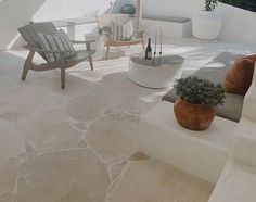 an outdoor living area with white walls and stone flooring