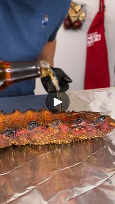 a person is cutting up food on a piece of tin foil with a large knife