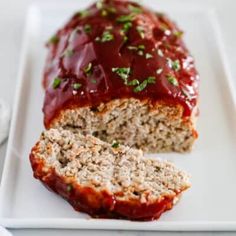 meatloaf with ketchup on a white plate