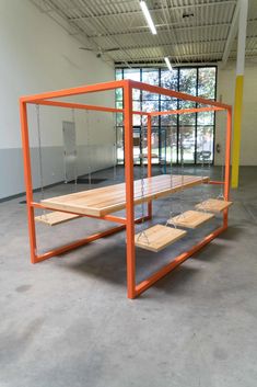 an orange metal structure with wooden shelves in the middle