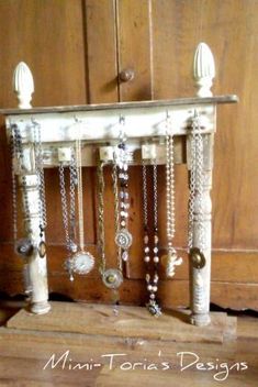 a wooden table topped with lots of beads and necklaces hanging from it's sides