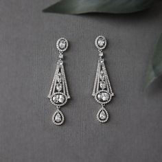 These enchanting Art Deco inspired earrings will have you feeling like royalty. Crafted from bright oval cut cubic zirconia stones, they make for the perfect special occasion accessory. These earrings measure about 2.5 inches long and have postpierced backs. They are nickel, lead, and cadmium free rhodium plated brass with AAA CZ stones. Vintage Bridal Accessories, Bohemian Art, Cz Earrings, Vintage Bridal, Art Deco Inspired, Bridal Hair Accessories, Water Drop, Cz Stone, Bridal Accessories