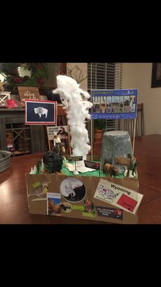 a cardboard box that has various items in it on a table with pictures and decorations