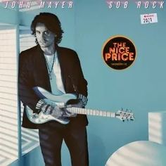 a man standing in front of a blue wall with a guitar on his chest and the words john mayer price above him