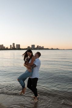 a man holding a woman in his arms while standing on the beach at sunset with text overlay that reads best couple photography poses