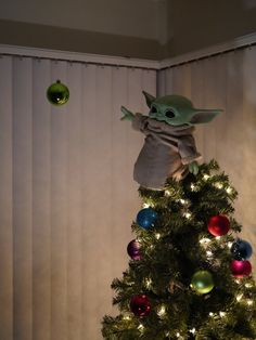 an ornament is hanging from the top of a christmas tree with lights on it