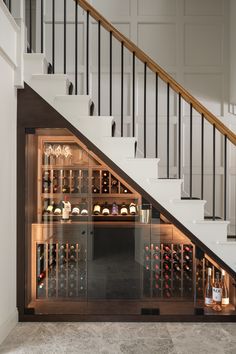 a wine cellar under the stairs in a house