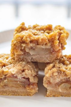 four pieces of dessert sitting on top of a white plate with crumb toppings