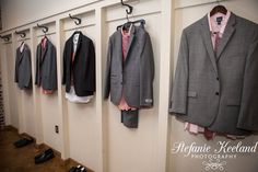 a row of suits hanging on the wall