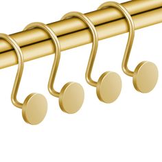 three gold hooks hang on the side of a curtain rod with four round knobs