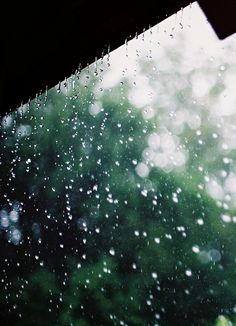 rain is falling down on the windshield of a car as it sits in front of a window