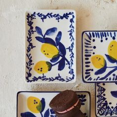 three blue and white plates with lemons on them, one has a chocolate cookie in the middle