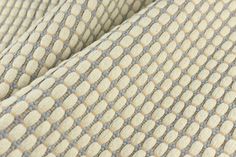 an up close shot of the fabric on a chair with grey and beige patterns in it