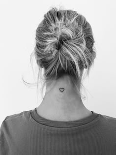 a woman with a small heart tattoo on her neck