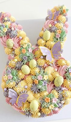 an easter bunny made out of pasta and decorated with pastel flowers, eggs and butterflies