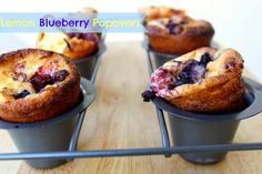 four blueberry muffins sitting on top of a metal tray next to each other