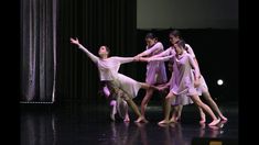 a group of young women standing on top of each other in front of a stage