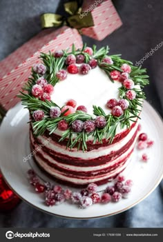 a three layer cake with cranberry frosting and fresh greenery on top