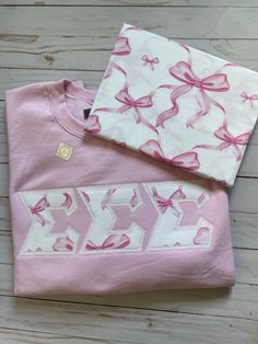 Good Golly Greek Pink Coquette Bow Sorority Stitched Letters. Looking for the perfect gift for the sorority sister in your life? Look no further! These letters are the perfect way to rep a sorority on and off campus. To order a pair for your chapter, click the link to our website. #Preppy#SororityApparel#StitchedLetters#SigmaSigmaSigma#BigLittleBasket#InitiationBasket#Embroidered#Coquette#Girly Sorority Embroidery, Sorority Sweatshirts Letters, Pink Sorority Letters Sweatshirt, Sorority Embroidered Sweatshirt, Sorority Letters Embroidery, Sorority Letters Sweatshirt, Stitched Letters Sorority, Sorority Events