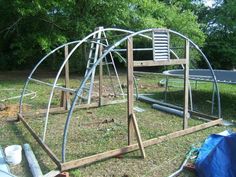 a wooden structure sitting on top of a grass covered field