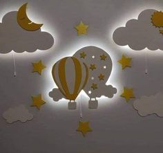 an illuminated hot air balloon in the sky with stars and moon cutouts on it