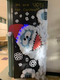 a door decorated to look like a monster with lights and decorations on it, in the middle of a hallway