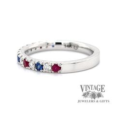 a white gold ring with red, blue and white stones on the inside of it