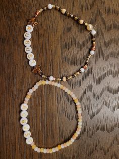 two beaded bracelets sitting on top of a wooden table