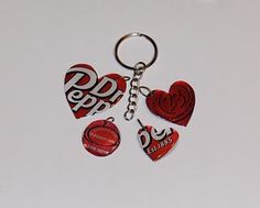 three heart shaped key chains with the word pdp on them are hanging from a chain