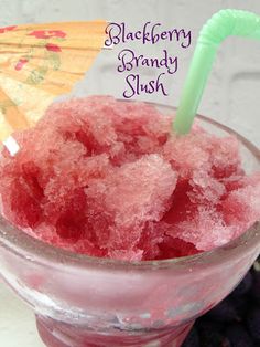 a pink drink with a green straw in a glass next to an umbrella and blueberries