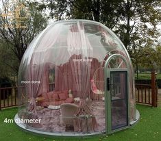 an inflatable tent is set up on the lawn with chairs and tables inside