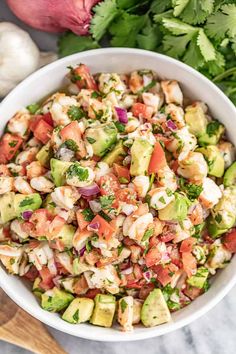 a white bowl filled with chopped vegetables and garnished with cilantro