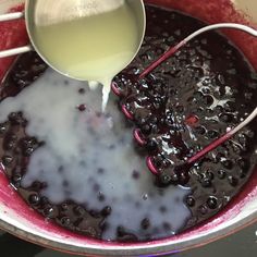 blueberry sauce being poured into a pot