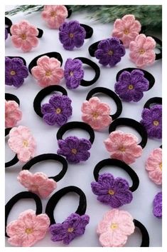 crocheted flowers and black rings on a white surface