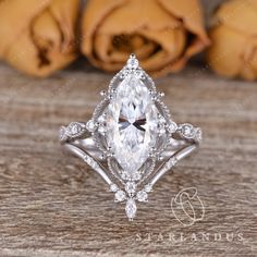 an engagement ring with a pear shaped diamond in the center and two roses behind it