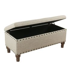 an upholstered ottoman with studding on the legs and footrests is shown