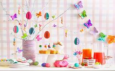 a table topped with lots of different types of food and drink bottles next to a vase filled with butterflies