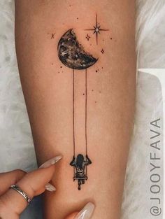 a woman's arm with a tattoo on it that has an image of the moon and