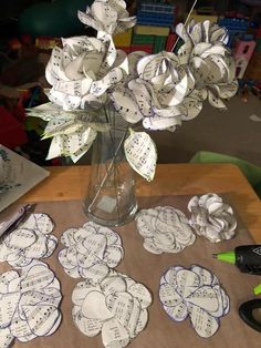 a vase filled with flowers sitting on top of a wooden table next to sheet music