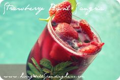 there is a drink with strawberries in it next to a pool and the words strawberry basil sangria