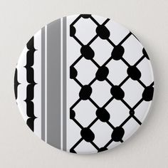 a black and white geometric pattern on a round pinback button that is attached to a wall