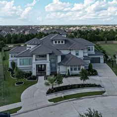 an aerial view of a large house with lots of trees and grass in the front yard